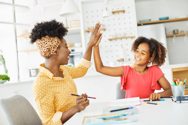 homework teaching girl high five education mother children daughter familiy childhood success child african american stock photo