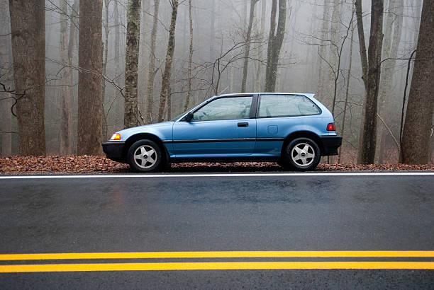 1991 Honda Civic hatchback on side of road Shady Valley, TN, USA - November 30, 2009: A blue 1991 Honda Civic hatchback parked on the edge of a wet road in a foggy forest 1991 stock pictures, royalty-free photos & images