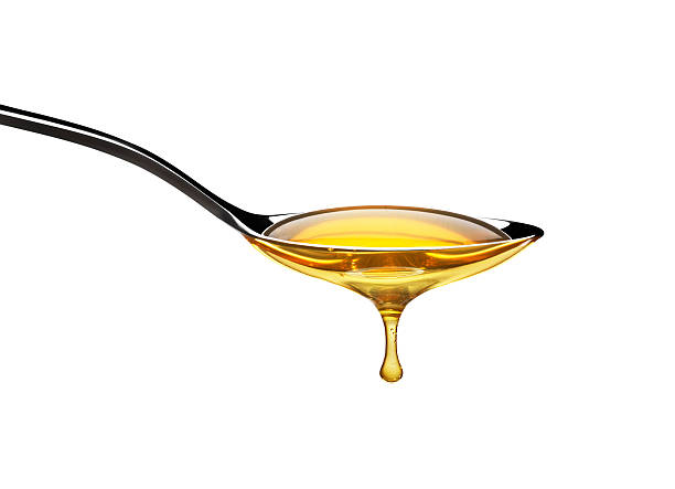 honey dripping from spoon - honing stockfoto's en -beelden