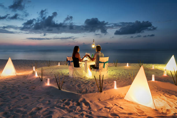 Honeymoon couple is having a private, romantic dinner Honeymoon couple is having a private, romantic dinner at a tropical beach maldives stock pictures, royalty-free photos & images