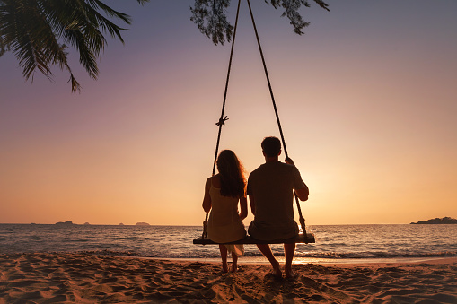 honeymoon travel, silhouette of romantic couple on sunset  beach, tropical holidays near the sea, man and woman together on vacation