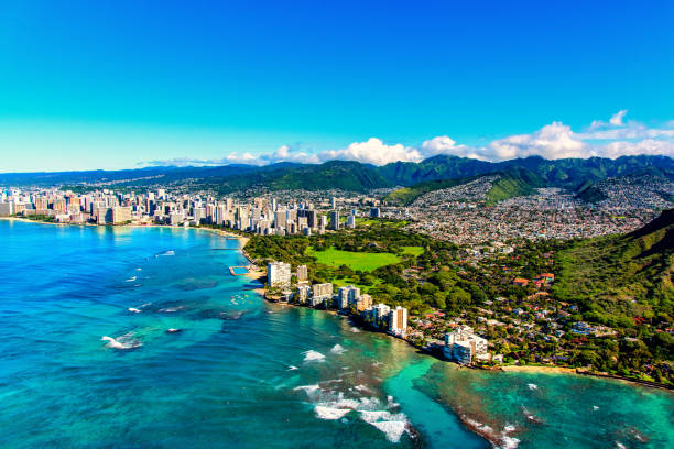 Honolulu Hawaii from Above The entire coastline of Honolulu, Hawaii including the base of Diamond Head crater and state park, past the hotel lined Waikiki Beach towards downtown in the distance including the suburban neighborhoods dotting the hills surrounding the city center. honolulu stock pictures, royalty-free photos & images