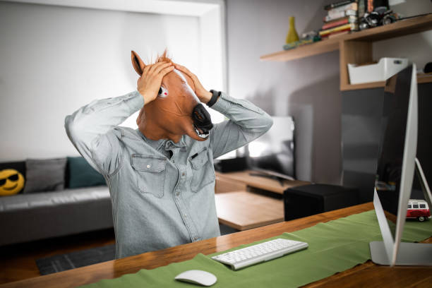Horseman  with horse mask working at home office Business man with horse mask working at home office horse mask photos stock pictures, royalty-free photos & images