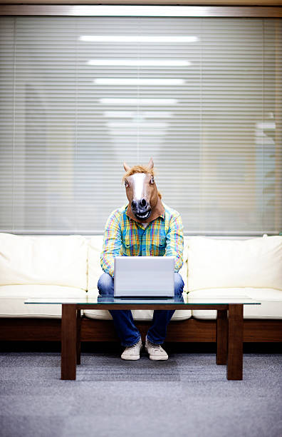 Horseman with laptop A man wearing a horses head, working on his laptop. horse mask photos stock pictures, royalty-free photos & images