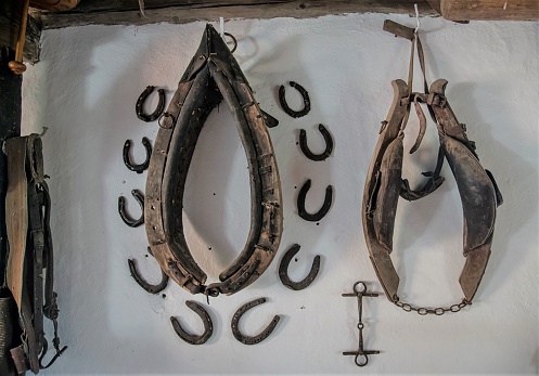 Feldkirchen/Austria - 10/22/2020: Horseshoes and harness used as wall decoration of a traditional farmhouse in the Austrian region of Carinthia