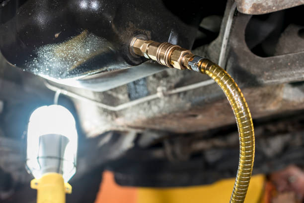 A hose is connected to Oil drain plug of a SUV. For engine oil flush procedure. stock photo