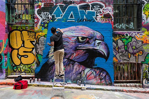 Hosier Lane in Melbourne, Australia Melbourne, Australia - Sep 9, 2015: Street artist creating graffiti at Hosier Lane in Melbourne, Australia. Hosier Lane is a laneway in CBD of Melbourne, It is a popular landmark in Melbourne due to its graffitti covered walls and urban art. melbourne street stock pictures, royalty-free photos & images