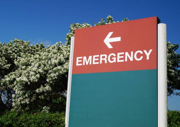 Hospital Emergency Sign An outdoor green and red sign pointing in the direction of the hospital emergency department inpatient stock pictures, royalty-free photos & images