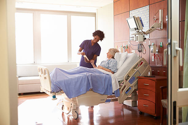 Hospital Nurse With Digital Tablet Talks To Senior Patient Hospital Nurse With Digital Tablet Talks To Senior Patient patient in hospital bed stock pictures, royalty-free photos & images