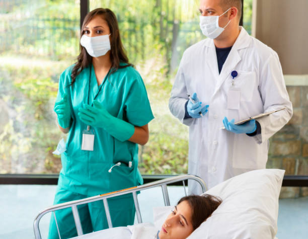 Hospital Workers Attending to Young Woman in Hospital stock photo