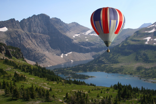 A hot air balloon looking down on a Mountain lake
