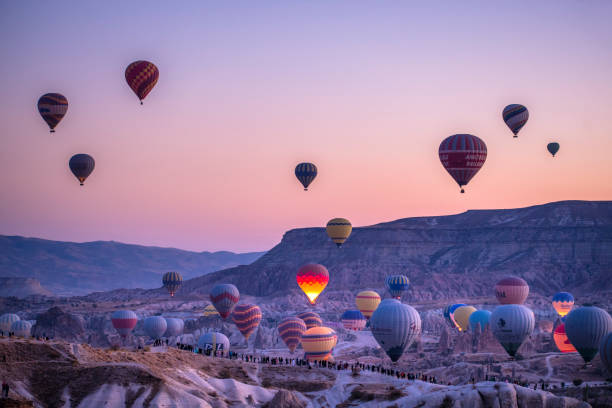 Hot air ballons at Cappadocia, Turkey at sunrise Hot air ballons at Cappadocia, Turkey at sunrise, early in the morning, pink sky, beautiful sunrise. Hot air ballon rising up in the air. turkey country stock pictures, royalty-free photos & images
