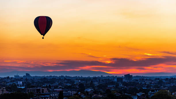 Hot air balloons float above Melbourne suburbs Melbourne, Victoria, Australia, April 2nd 2021: Hot air balloons float above Melbourne suburbs, from Brunswick looking towards the east. zero gravity carnival ride stock pictures, royalty-free photos & images