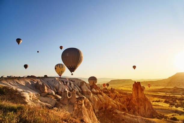 Hot Air Balloons Flying at Sunset, Cappadocia, Turkey Hot Air Balloons Flying at Sunset, Cappadocia, Turkey hot air balloon stock pictures, royalty-free photos & images
