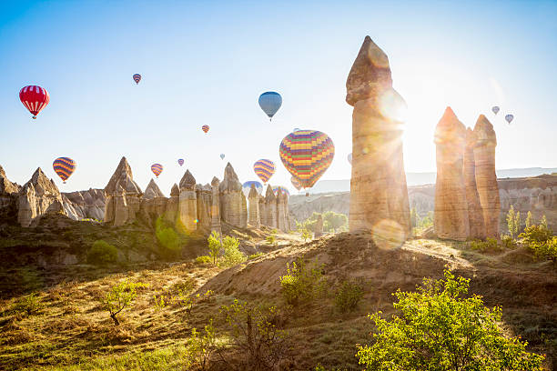 Hot air balloons over Love Valley, Cappadocia, Turkeys Hot air ballons over Love Valley near Goreme and Nevsehir in the center of Cappadocia, Turkey (region of Anatolia). This shot taken shortly after sunrise shooting into the sun. Sun flares visible. rock hoodoo stock pictures, royalty-free photos & images