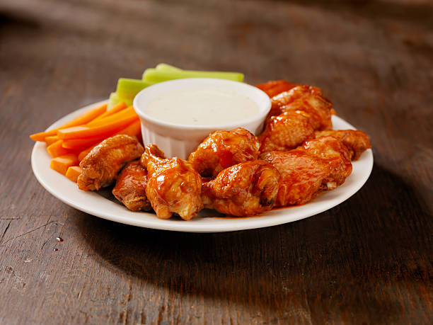Hot Chicken Wing Platter "A Dozen Hot Chicken Wings with Celery, Carrots and Blue Cheese Dip-Photographed on Hasselblad H3D-39mb Camera" chicken bird stock pictures, royalty-free photos & images