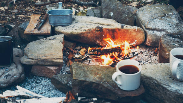 Hot coffee or tea in mugs near campfire. Hiking tourism concept Hot coffee or tea in mugs near campfire. Hiking tourism concept bushcraft stock pictures, royalty-free photos & images