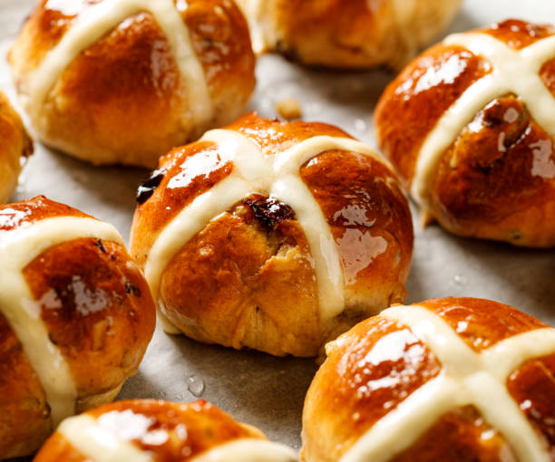 Hot cross buns,freshly baked hot cross buns on white parchment paper, close-up. stock photo