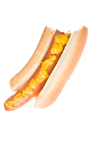 Hot Dog With  A Bite Missing A close up of a hot dog in a white bun and mustard and a bite missing. Isolated on white. eaten stock pictures, royalty-free photos & images