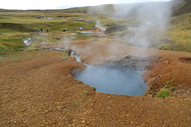 Hot greyish blue pool in the Reykjadalur valley. People walk in the valley of Reykjadalur stock photo