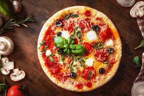 Hot pizza with Pepperoni  with vegetables and fresh ingredients on rustic wooden table. Pizza menu. View from above. Hot pizza with Pepperoni  with vegetables and fresh ingredients on rustic wooden table. Pizza menu. View from above. garlic photos stock pictures, royalty-free photos & images