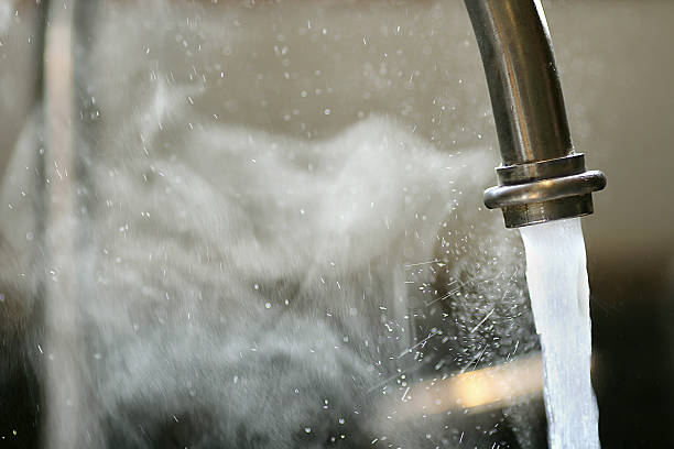 Hot Steaming Water Running from Kitchen Faucet stock photo