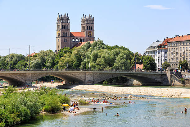Hot summer day at river Isar, Munich Munich, Germany - July 28, 2013: People swimming in the river Isar in Munich. In the background the bridge Reichenbachbruecke and the church St. Maximilian. Due to the renaturation and environmental protection it is possible today to enjoy the river on hot summer days. river isar stock pictures, royalty-free photos & images