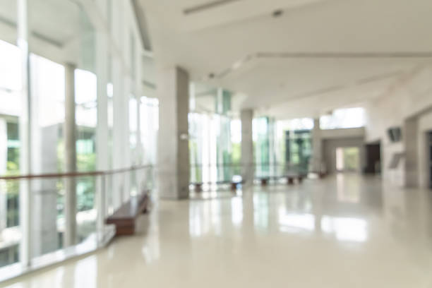 Hotel or office building lobby blur background interior view toward reception hall, modern luxury white room space with blurry corridor and building glass wall window  Lobby stock pictures, royalty-free photos & images