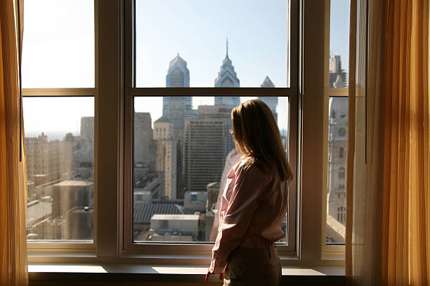 Hotel room with a view Philly'buster - Woman relaxing in her hotel room staring stock pictures, royalty-free photos & images