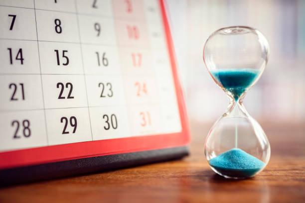 Hourglass and calendar Hour glass and calendar concept for time slipping away for important appointment date, schedule and deadline deadline stock pictures, royalty-free photos & images