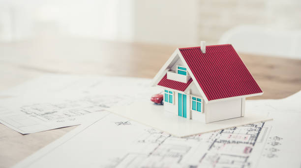 huis model met blauwdruk monster voor vastgoedontwikkeling - een nieuw huis bouwen stockfoto's en -beelden