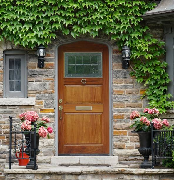 House with elegant wood grain front door surrounded by ivy stock photo