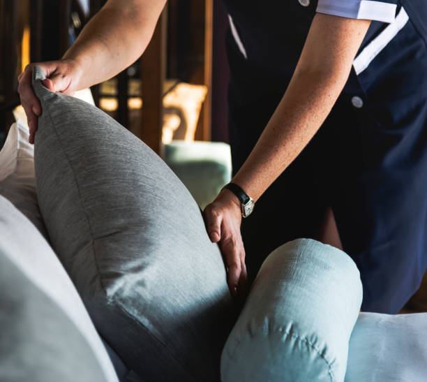 ama de casa limpieza de una habitación de hotel - fluffing cushions fotografías e imágenes de stock