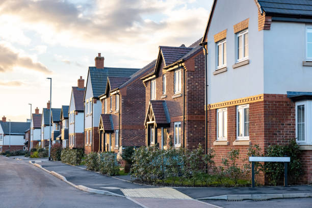 Houses in England with typical red bricks at sunset - Main street in a new estate with typical British houses on the side - Real estate and buildings concepts in UK stock photo