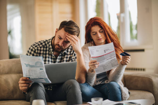 How are we going to pay these bills? Worried couple feeling frustrated while have to pay their bills over Internet. bankruptcy stock pictures, royalty-free photos & images