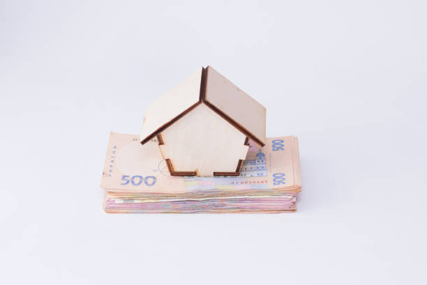 uah hryvnia 鈔票與木房子查出在白色背景。烏克蘭的錢。抵押貸款或買房的概念 - shevchenko 個照片及圖片檔