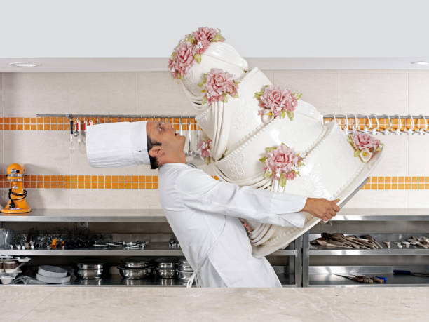 Chef carrying a huge cake in a bakery