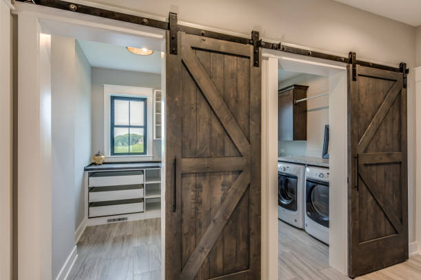 Huge laundry room with barn doors entrance Light hardwood floors throughout new house utility room photos stock pictures, royalty-free photos & images