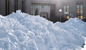 Huge snowdrifts in Moscow under bright winter sun near the entrance to a library