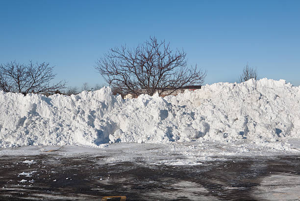 huge snowpiles in plowed parking lot stock photo