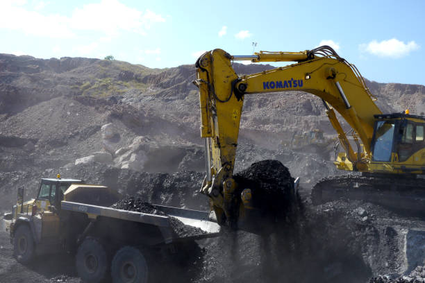 Huge trucks excavate coal from an open caste coal mine. stock photo