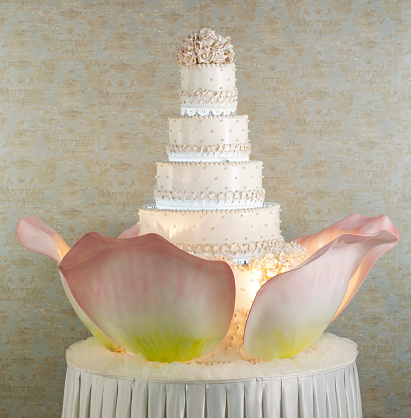 Huge wedding cake with blooming flower decor in white background