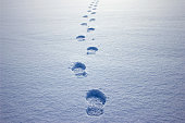istock Human footprints in the snow under sunlight close-up view 1298263597