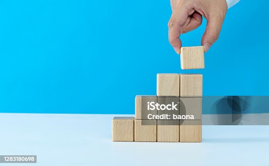 istock Human hand building stairs with blocks 1283180698