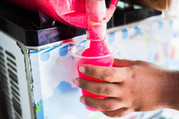 Human hand serving slushy drink from slushy  machine stock photo