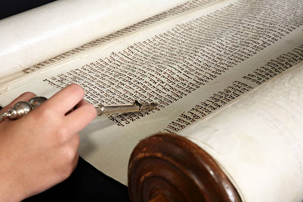 Human hand with a yad touching the torah. stock photo