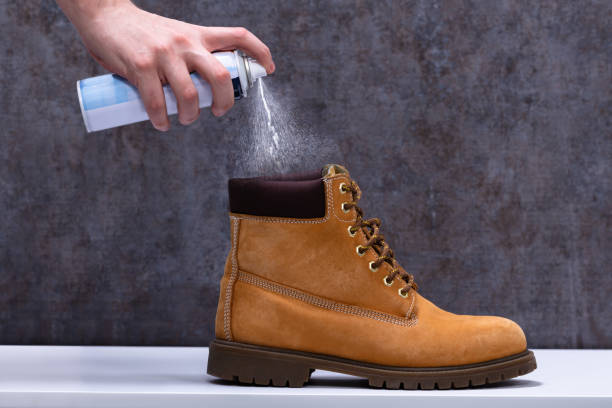 Human Spraying Deodorant On Shoes Human's Hand Spraying Deodorant On Smelly Shoes Over White Desk deodorant stock pictures, royalty-free photos & images