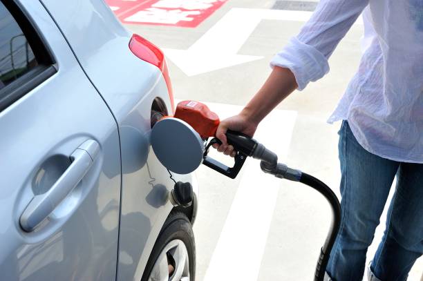 車にガソリンを入れる人間の手 - ガソリンスタンド ストックフォトと画像