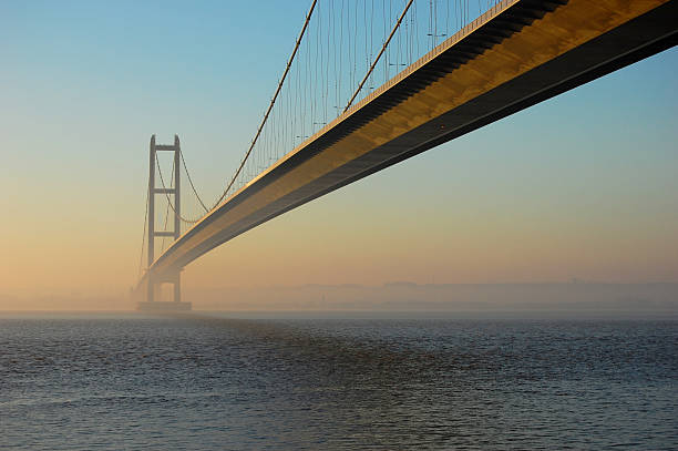 Humber Bridge at Twilight The view from the north bank of the River Humber on a misty morning. hull stock pictures, royalty-free photos & images