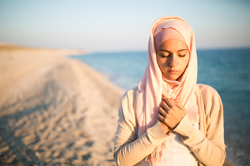 Humble Muslim Woman Praying On The Beachspiritual Humble Muslim Woman Praying On The Beachspiritual